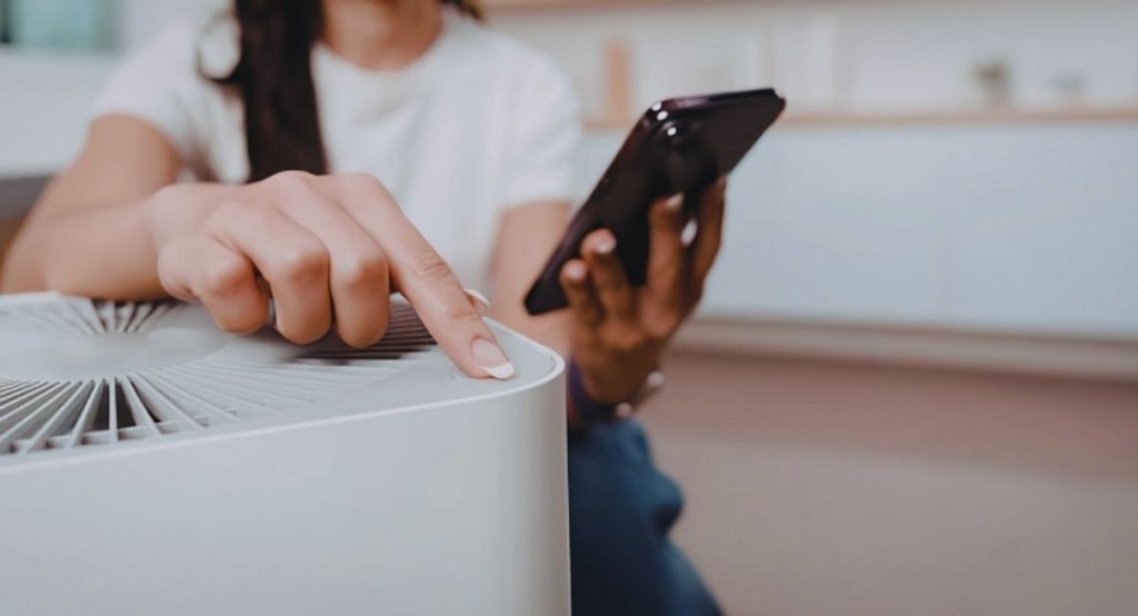 Femme interagissant avec un ioniseur ventilateur purificateur d'air