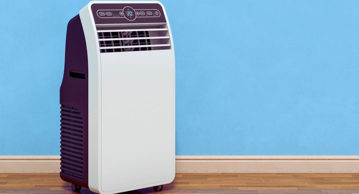 Climatiseur mobile blanc sur roulettes posé contre un mur