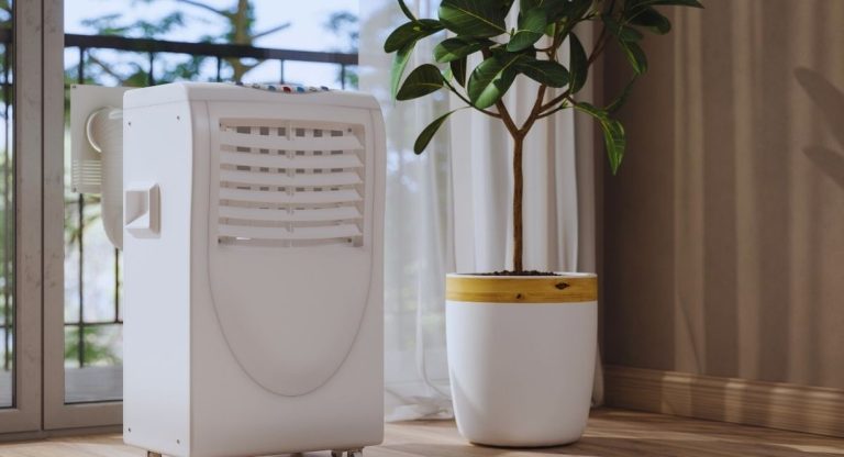 Climatiseur mobile blanc avec tuyau d'évacuation posé près d'une baie vitrée