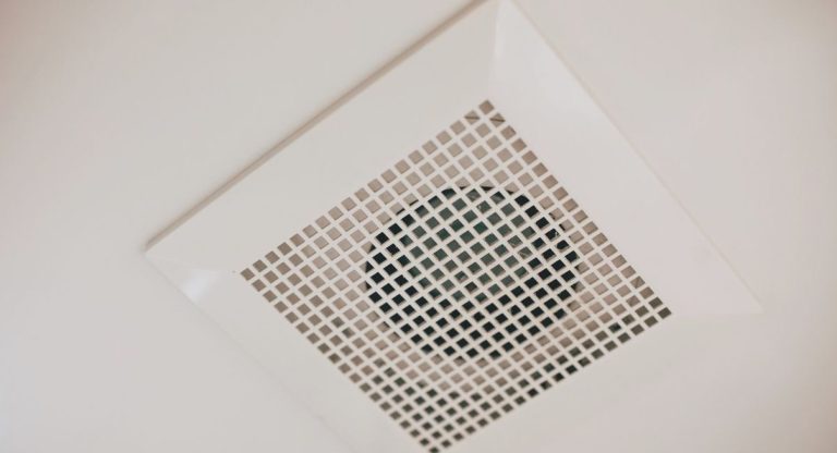 Grille de bouche d'extraction VMC installée au plafond blanc