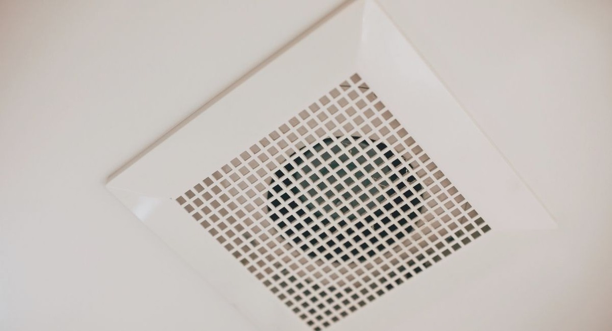 Grille de bouche d'extraction VMC installée au plafond blanc