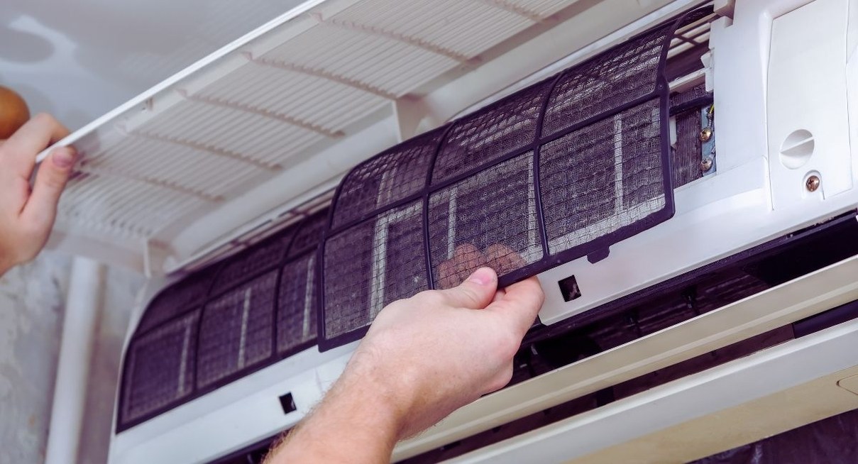 Mains retirant le filtre d'une unité intérieure de climatiseur split