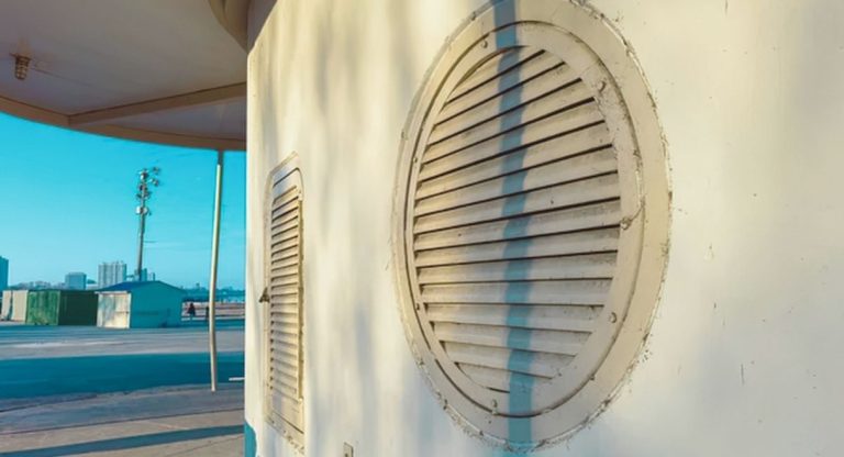 Grille de ventilation ronde installée sur un mur extérieur