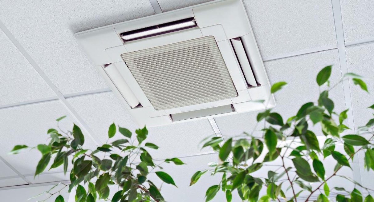 Unité de climatisation cassette encastrée dans le faux plafond d'un local professionnel